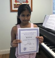 Here's an alt tag for the image: Smiling girl holding music achievement award.